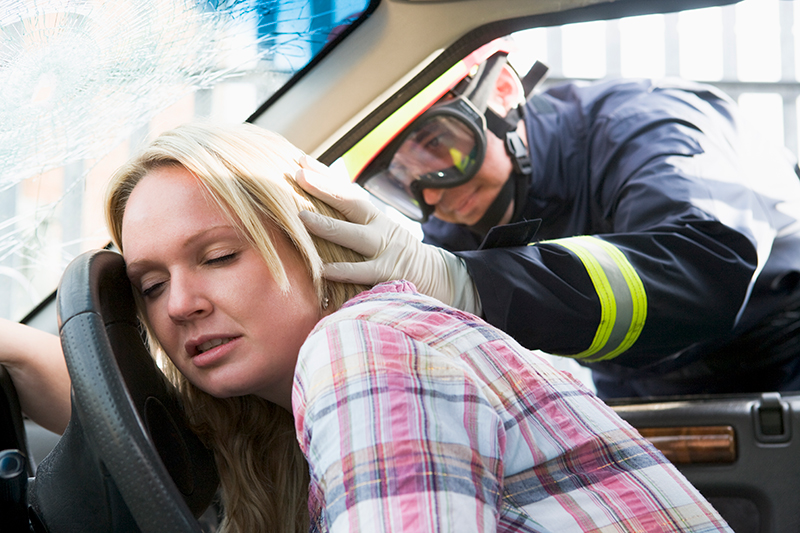 Injured woman being helped by firefighter in car